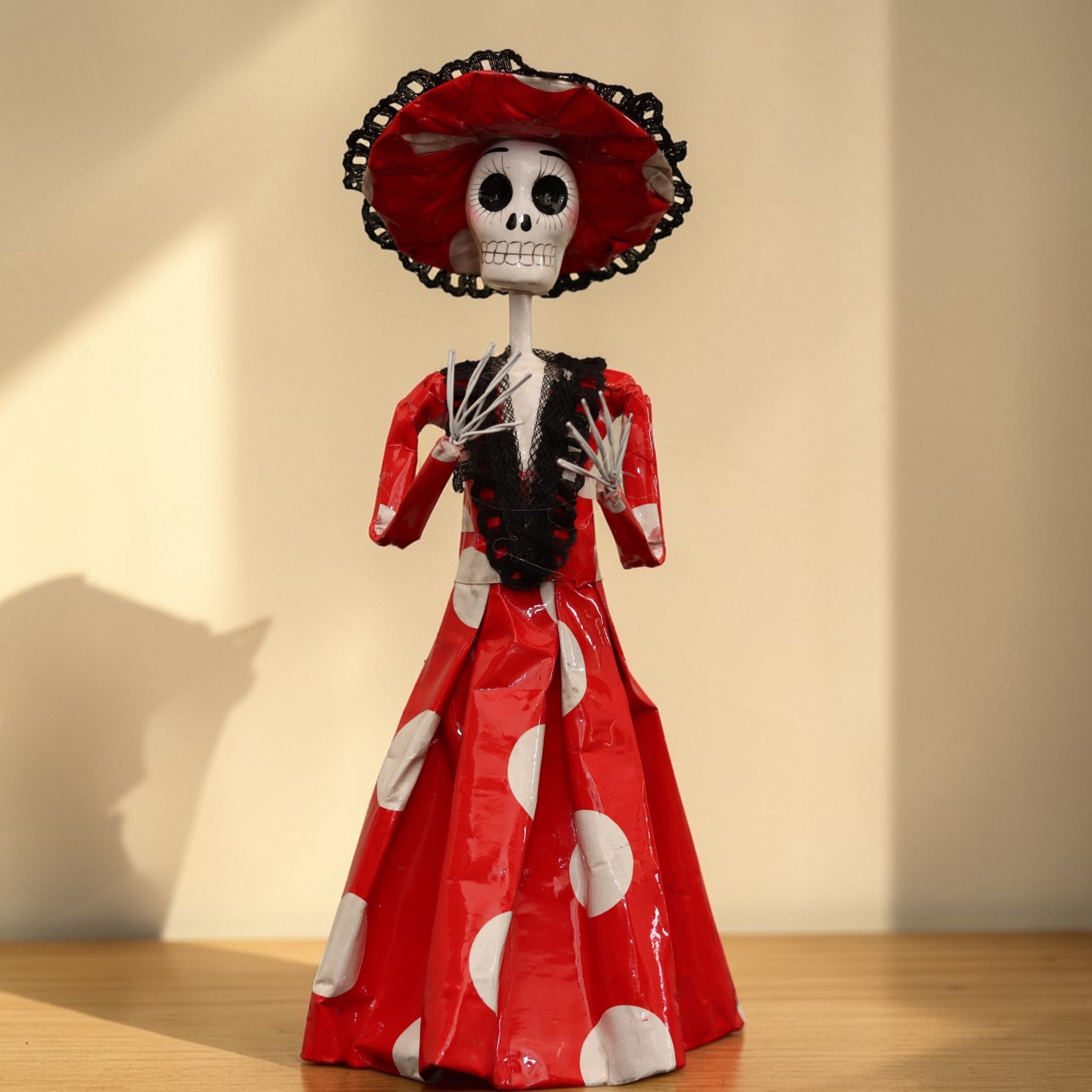 Close-up of hand-painted Catrina face with expressive eyes and serene smile, traditional Mexican folk art figurine inspired by José Guadalupe Posada