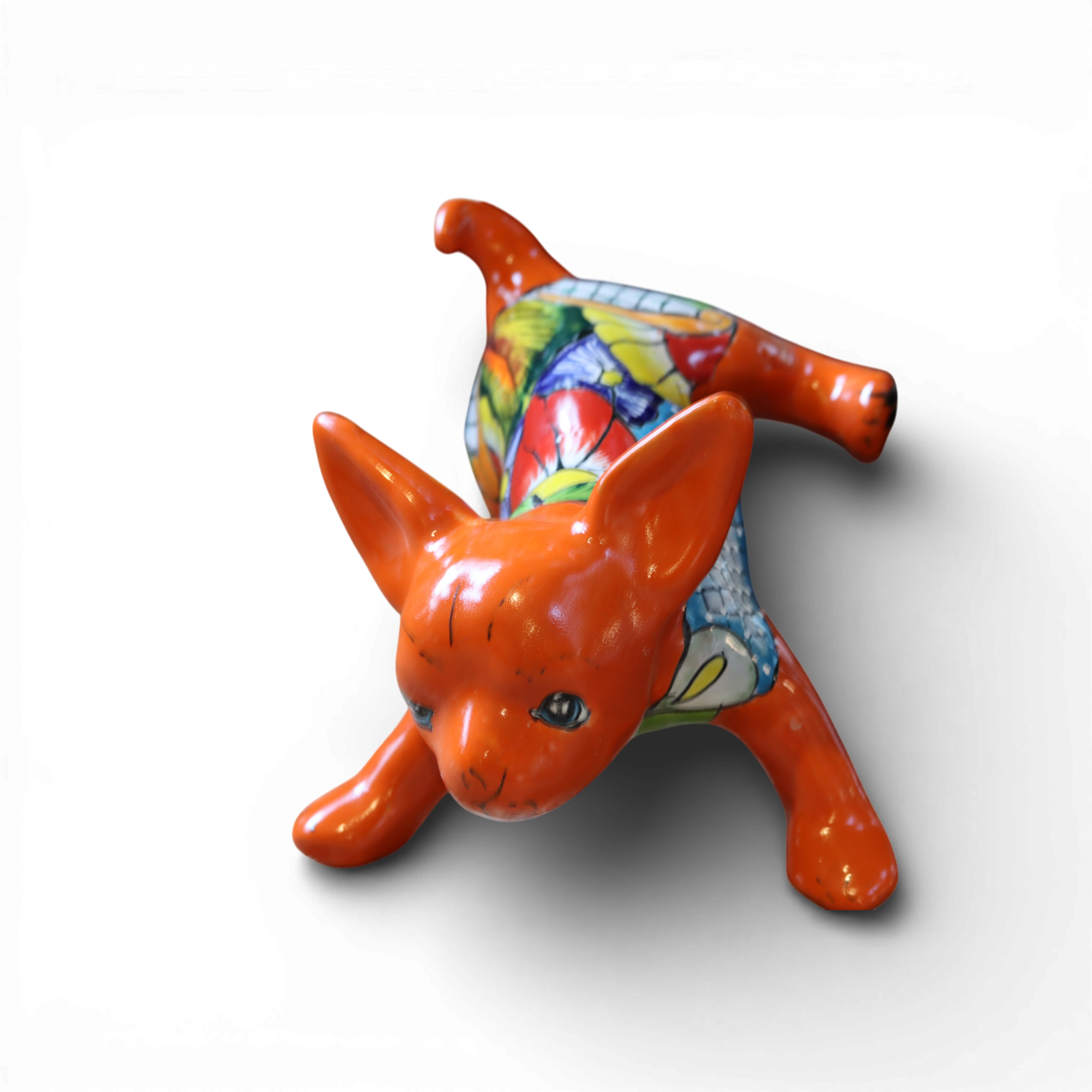 Hand painted Talavera chihuahua figurine with colorful Mexican ceramic design isolated on white background