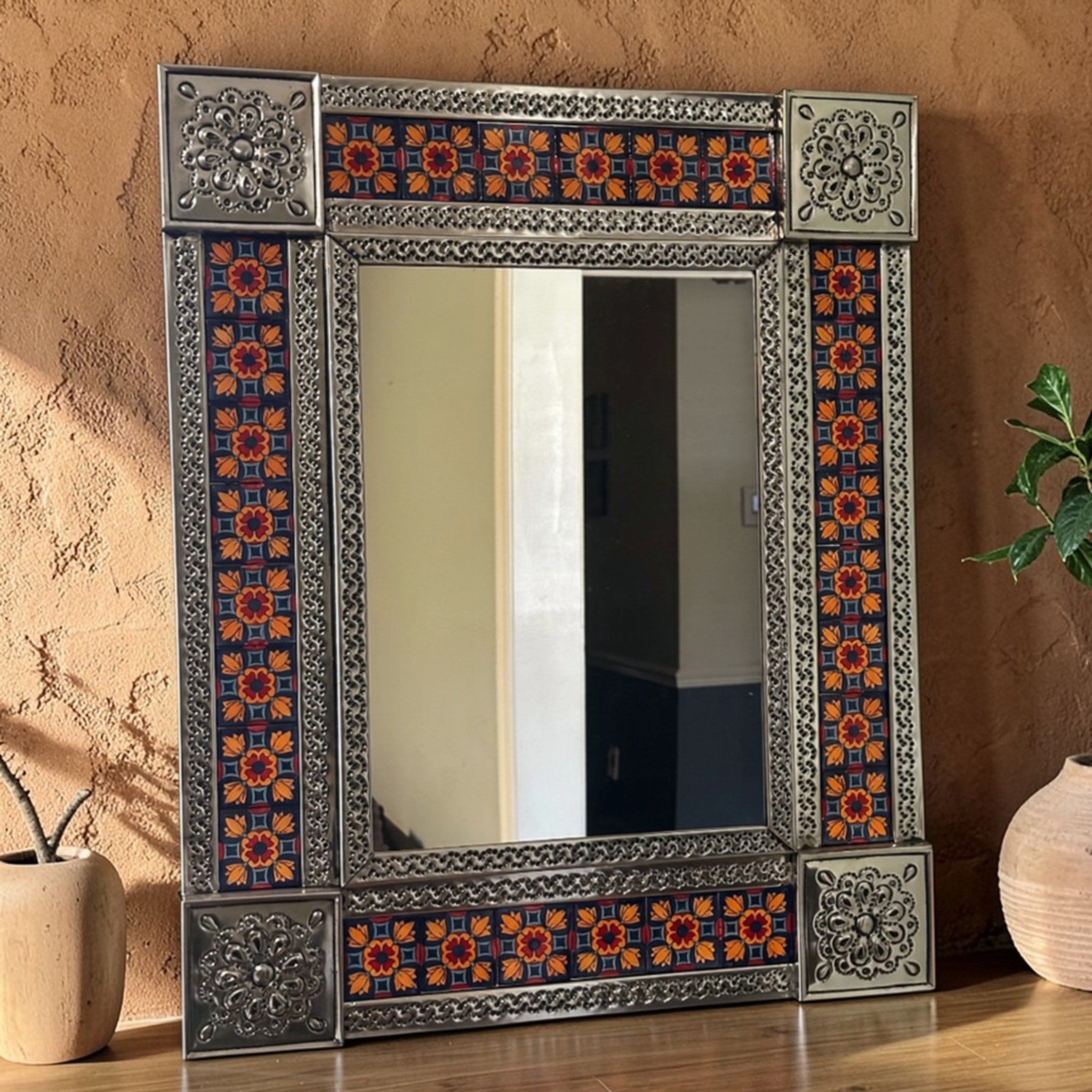 Handcrafted Talavera mirror with colorful Mexican ceramic tiles and ornate metal frame, styled in warm boho interior