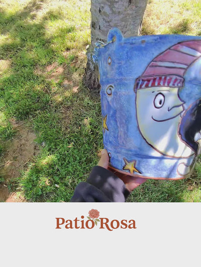 Patio Rosa moon cat planter — hand-painted blue ceramic bucket featuring a smiling crescent moon wearing a striped hat, surrounded by stars